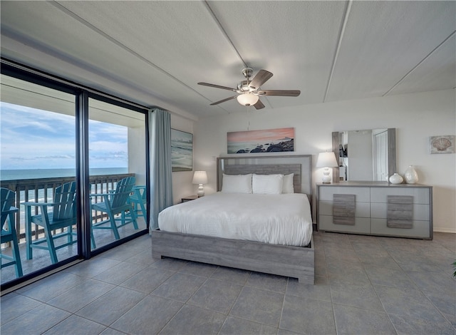 tiled bedroom with a textured ceiling, access to outside, a water view, and ceiling fan