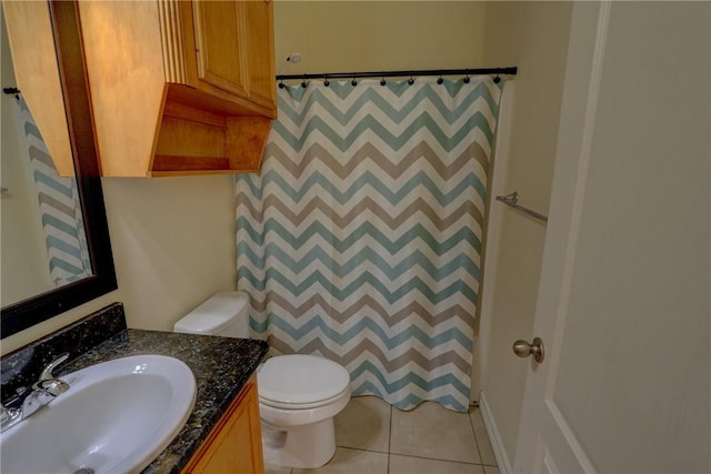 bathroom featuring toilet, vanity, tile patterned floors, and a shower with shower curtain