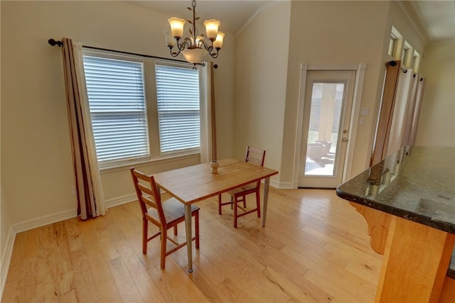 dining room with light wood-type flooring, healthy amount of natural light, and ornamental molding