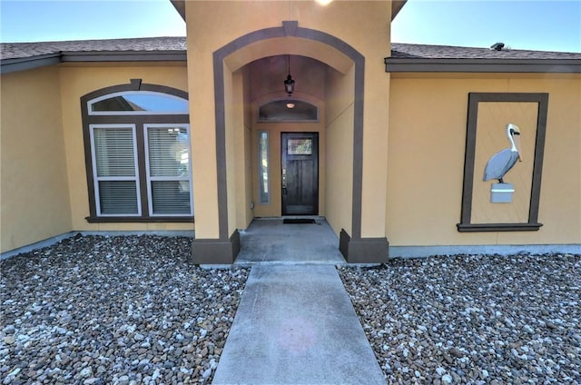 view of exterior entry featuring stucco siding