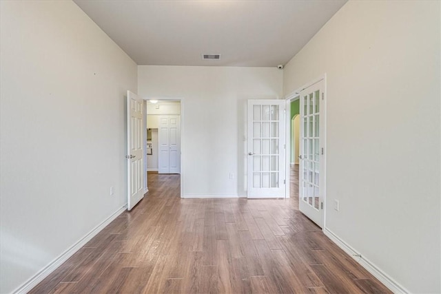 empty room featuring dark wood-type flooring and french doors