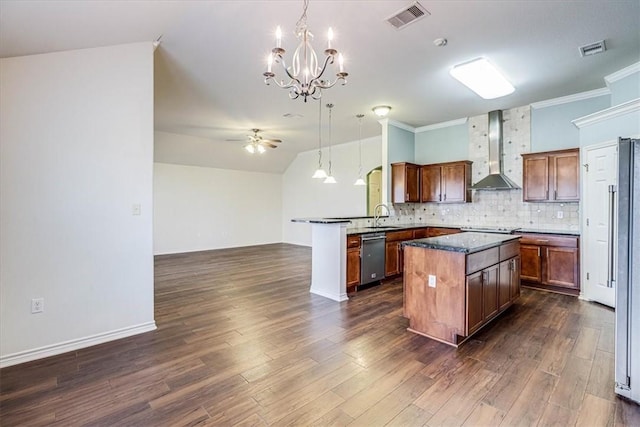 kitchen featuring sink, a center island, tasteful backsplash, decorative light fixtures, and wall chimney exhaust hood