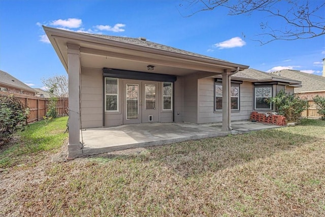 rear view of house featuring a patio and a lawn