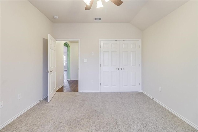 unfurnished bedroom with lofted ceiling, carpet floors, ceiling fan, and a closet