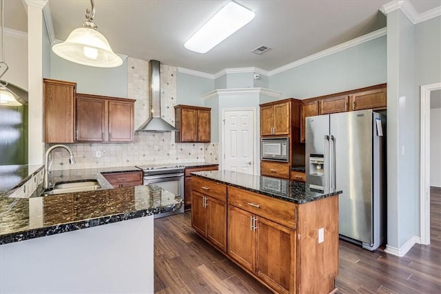 kitchen featuring appliances with stainless steel finishes, sink, dark stone countertops, decorative backsplash, and wall chimney range hood