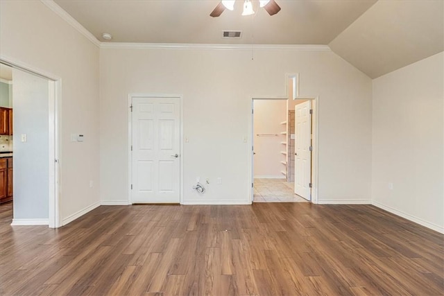 unfurnished bedroom featuring hardwood / wood-style flooring, vaulted ceiling, ornamental molding, and ceiling fan