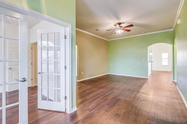 unfurnished room with dark wood-type flooring, ceiling fan, crown molding, and french doors