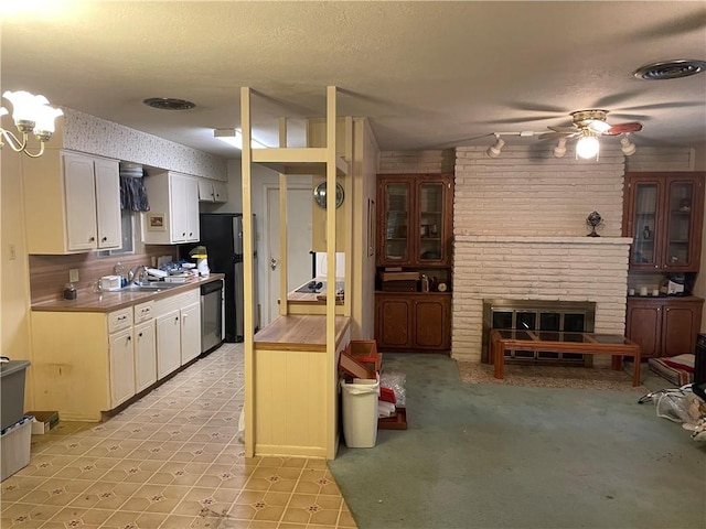 5406 Fresno Dr, Corpus Christi, TX 78411 - kitchen featuring dishwasher, a brick fireplace, white cabinets, a ceiling fan, and glass insert cabinets