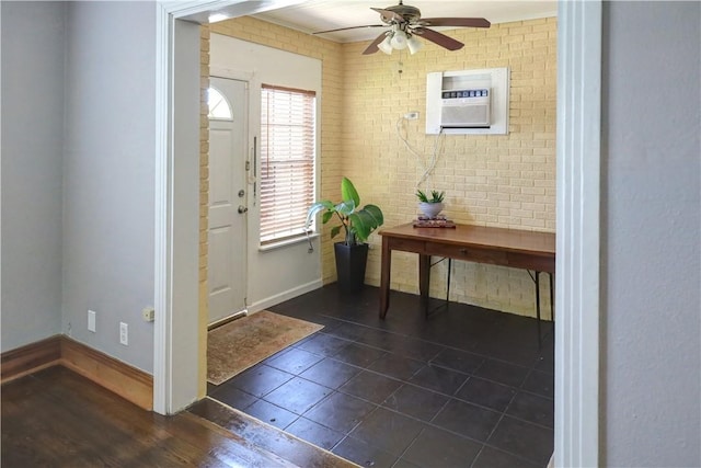 501 Del Mar Blvd, Corpus Christi, TX 78404 - entrance foyer featuring a wall unit AC, ceiling fan, dark tile patterned flooring, baseboards, and brick wall