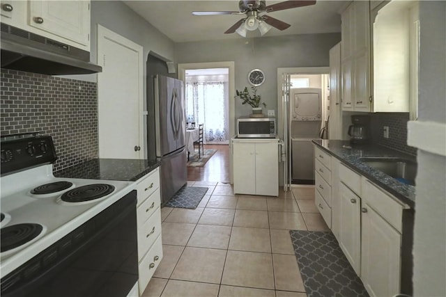 501 Del Mar Blvd, Corpus Christi, TX 78404 - kitchen featuring appliances with stainless steel finishes, stacked washing machine and dryer, under cabinet range hood, ceiling fan, and tasteful backsplash