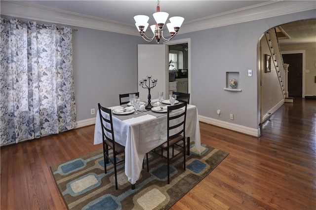 dining space with dark hardwood / wood-style flooring, a notable chandelier, and ornamental molding