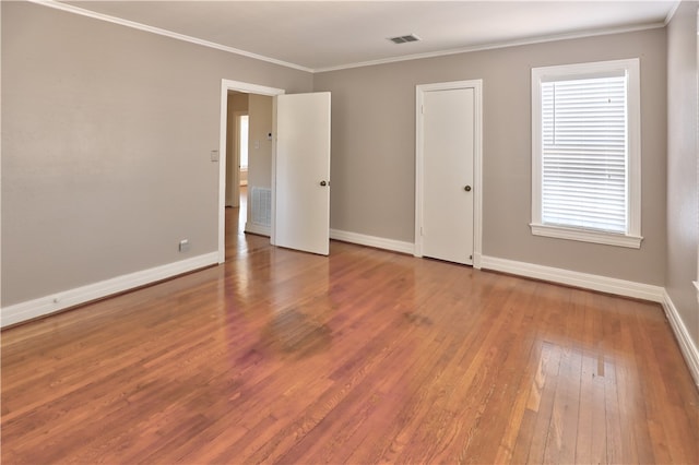 spare room with ornamental molding and hardwood / wood-style floors