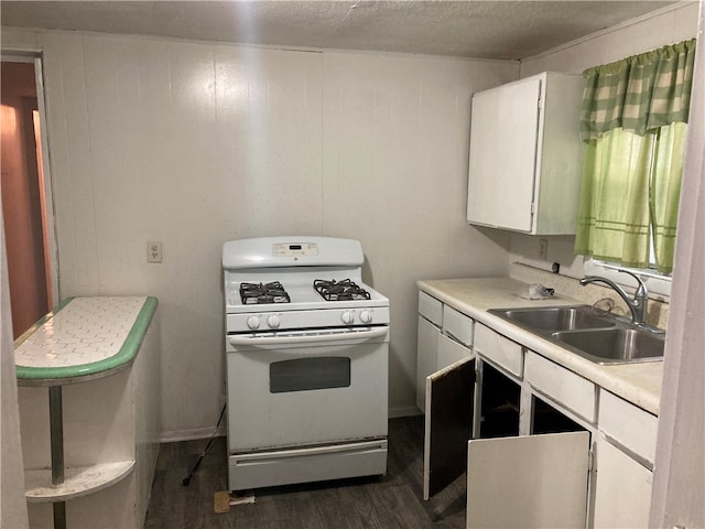 kitchen featuring a textured ceiling, sink, dark hardwood / wood-style floors, gas range gas stove, and white cabinetry