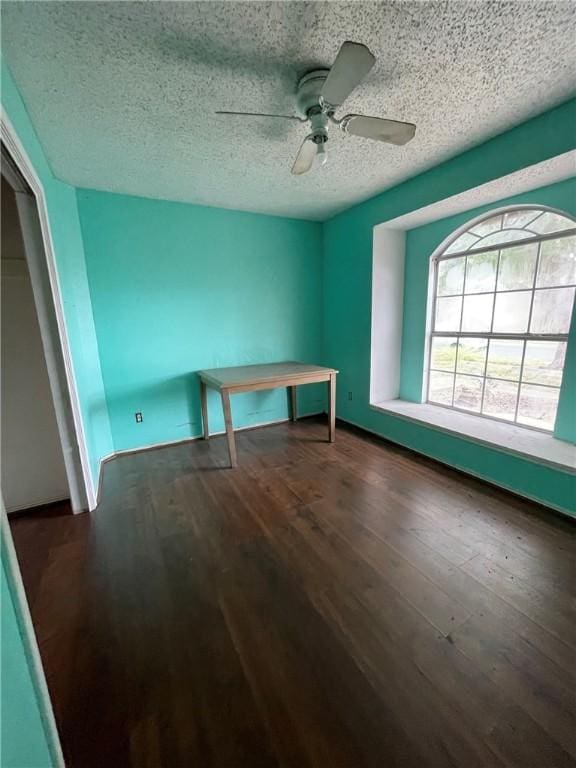 interior space with ceiling fan, dark wood-type flooring, and a textured ceiling