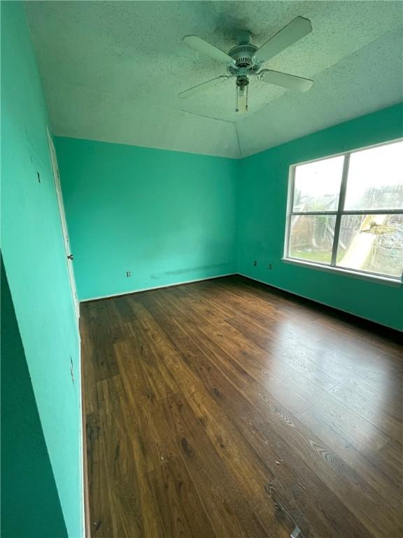 interior space featuring ceiling fan, dark hardwood / wood-style flooring, and a textured ceiling