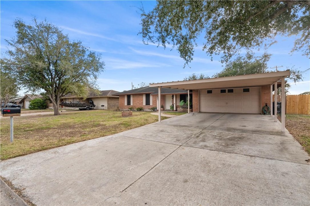 single story home featuring a carport, a garage, and a front yard