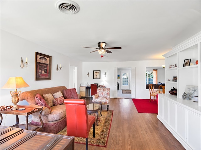 living room with ceiling fan and dark wood-type flooring