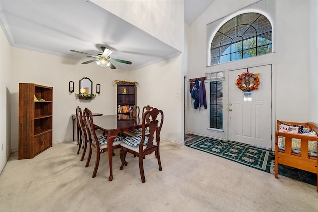 dining area with light colored carpet, ceiling fan, and ornamental molding