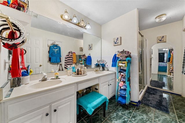 bathroom with tile patterned floors, vanity, a shower with shower door, and a textured ceiling