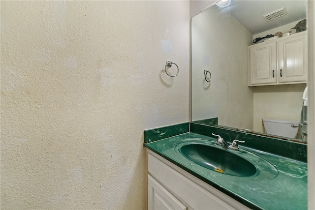 bathroom featuring vanity and toilet