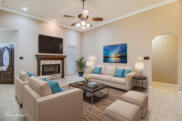 tiled living room with ornamental molding, ceiling fan, and a high end fireplace