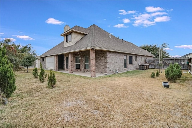 rear view of property with a yard, a patio, and central air condition unit