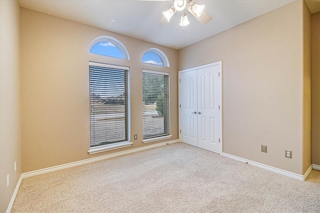 spare room with light colored carpet and ceiling fan