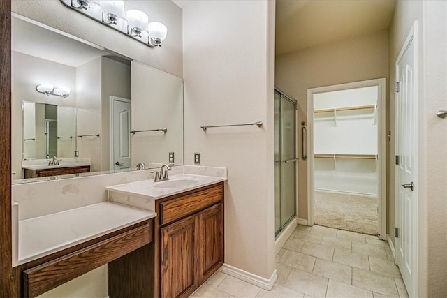 bathroom with walk in shower, vanity, and tile patterned flooring