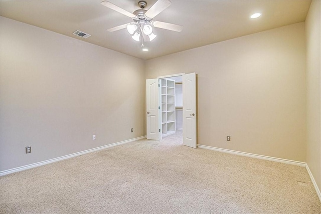 carpeted spare room featuring ceiling fan