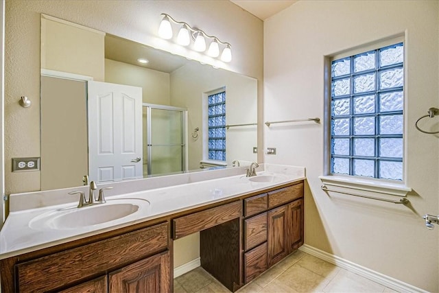 bathroom featuring a shower with door, vanity, and tile patterned flooring