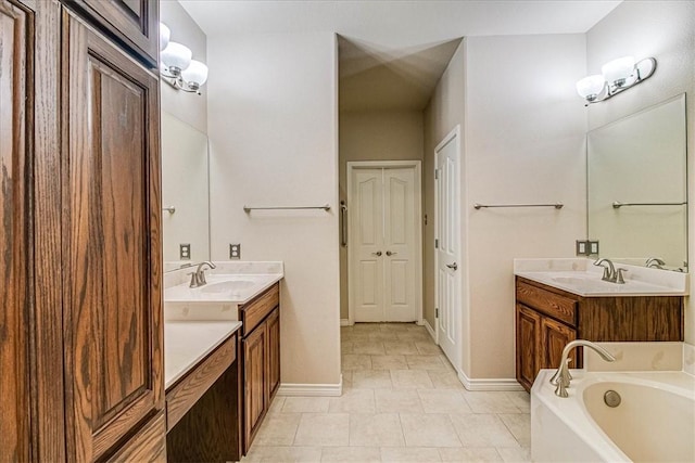 bathroom featuring vanity, tile patterned flooring, and a washtub