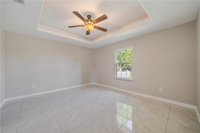 unfurnished room with ceiling fan, baseboards, visible vents, and a raised ceiling