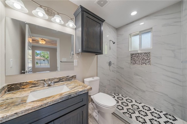 bathroom featuring vanity, a ceiling fan, visible vents, toilet, and a marble finish shower