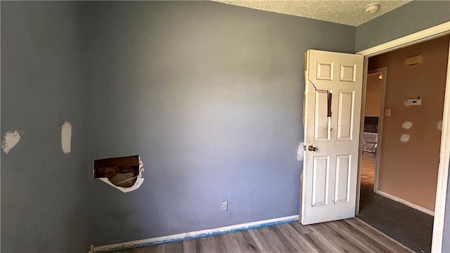 2993 Todd Cir, Ingleside, TX 78362 - unfurnished room with a smoke detector, wood finished floors, a textured ceiling, and baseboards