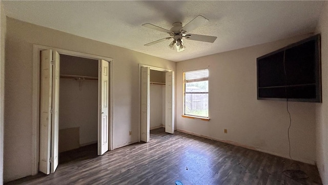 2993 Todd Cir, Ingleside, TX 78362 - unfurnished bedroom with two closets, dark wood-style flooring, baseboards, a textured ceiling, and a ceiling fan