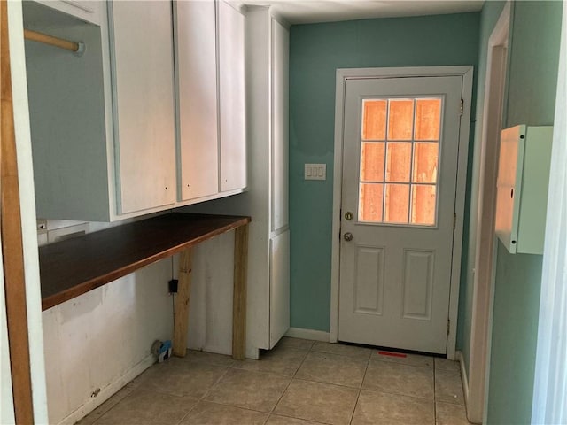 doorway to outside with baseboards and light tile patterned floors