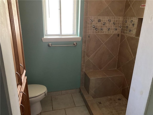 bathroom with tile patterned flooring, baseboards, a stall shower, and toilet