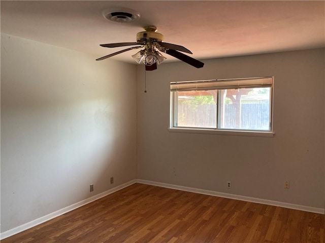 unfurnished room featuring baseboards, ceiling fan, visible vents, and wood finished floors