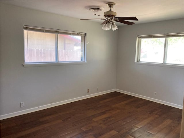 spare room with baseboards, ceiling fan, wood finished floors, and visible vents