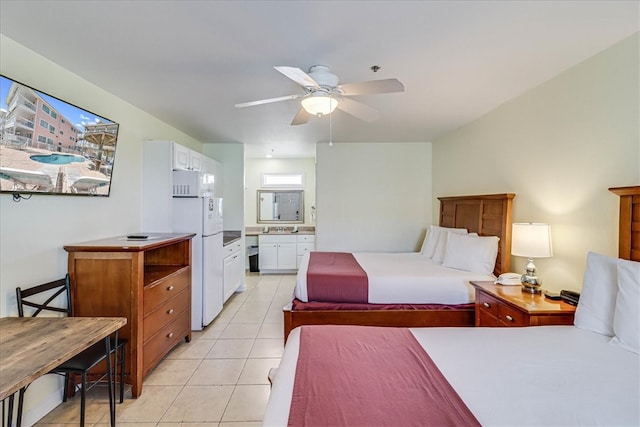 tiled bedroom featuring ceiling fan, sink, white refrigerator, and connected bathroom