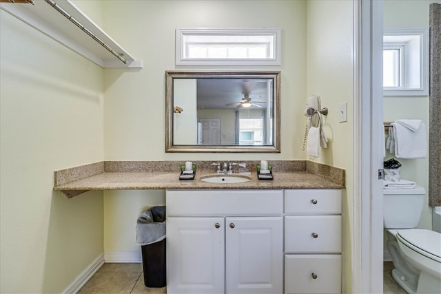 bathroom featuring tile patterned flooring, a wealth of natural light, vanity, and toilet