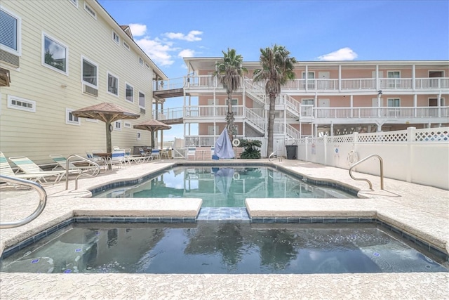 view of swimming pool with a community hot tub and a patio