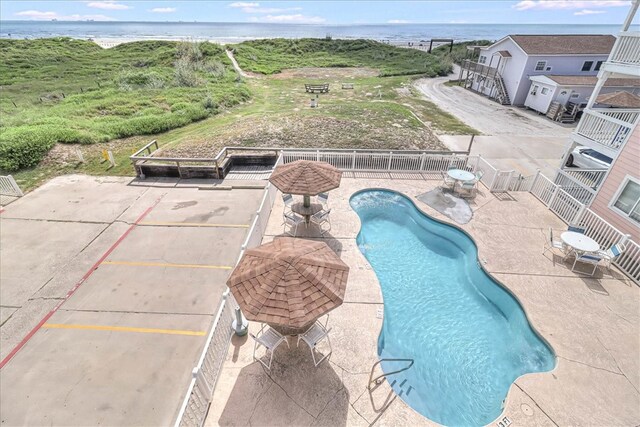 view of swimming pool with a water view and a patio area