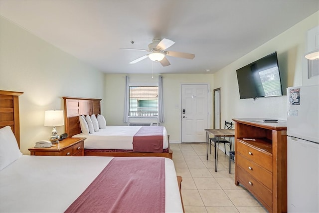 bedroom featuring light tile patterned floors, ceiling fan, and white fridge