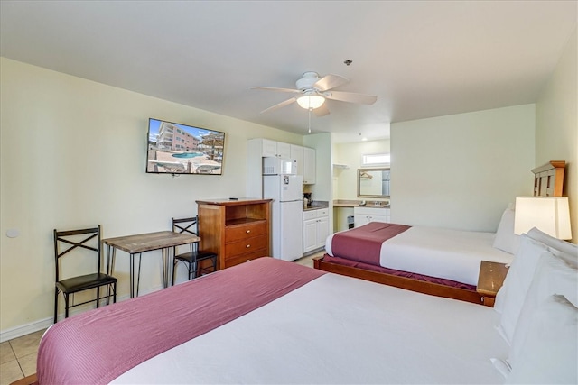 bedroom with light tile patterned floors, ceiling fan, connected bathroom, and white fridge