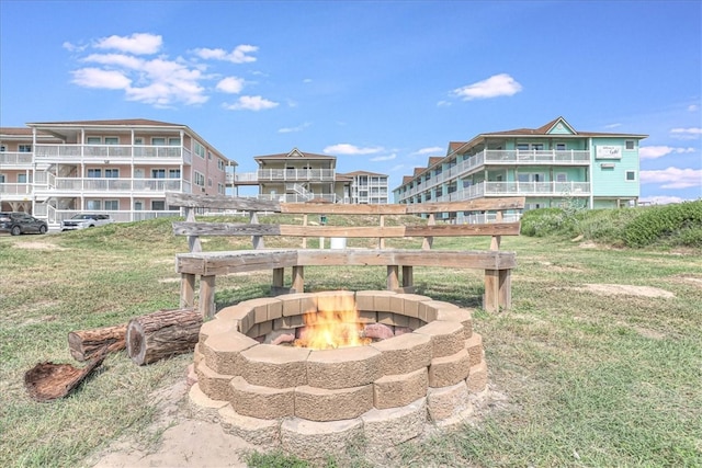 exterior space with an outdoor fire pit and a balcony