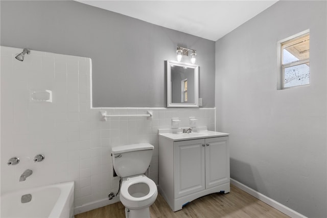 full bathroom featuring hardwood / wood-style floors, vanity, bathtub / shower combination, toilet, and tile walls