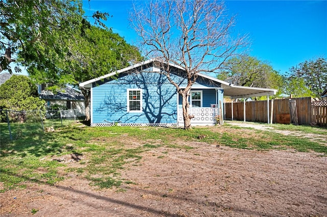 back of house featuring a carport