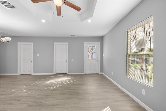 entryway with plenty of natural light, ceiling fan with notable chandelier, and light hardwood / wood-style flooring