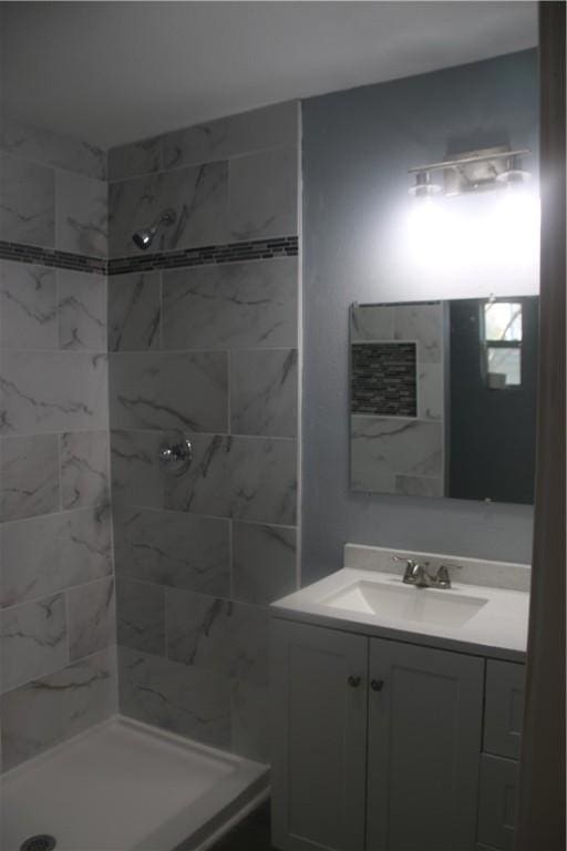 bathroom with vanity and a tile shower